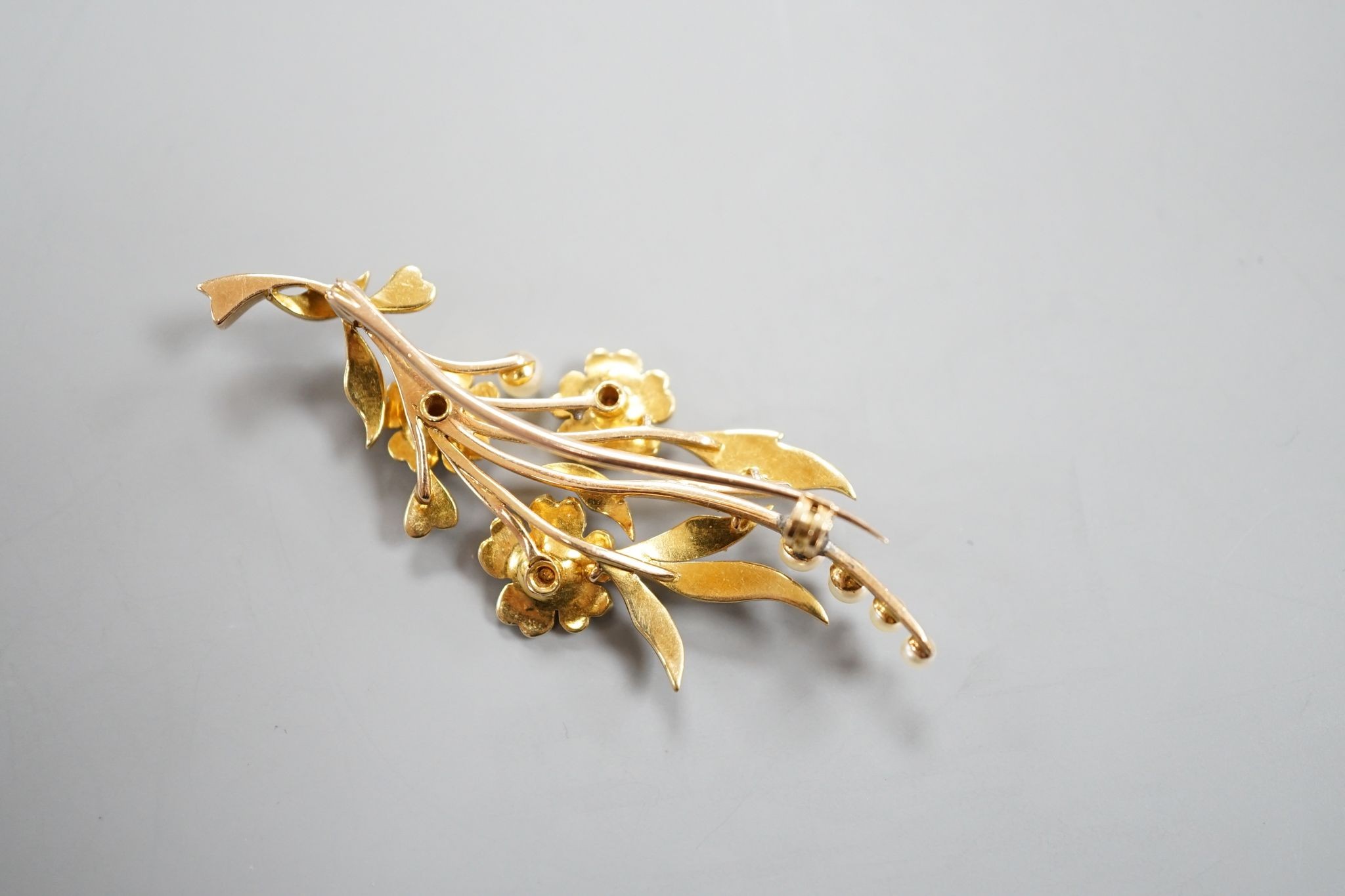 An Edwardian yellow metal and seed pearl set spray brooch, 58mm, gross weight 8.7 grams.